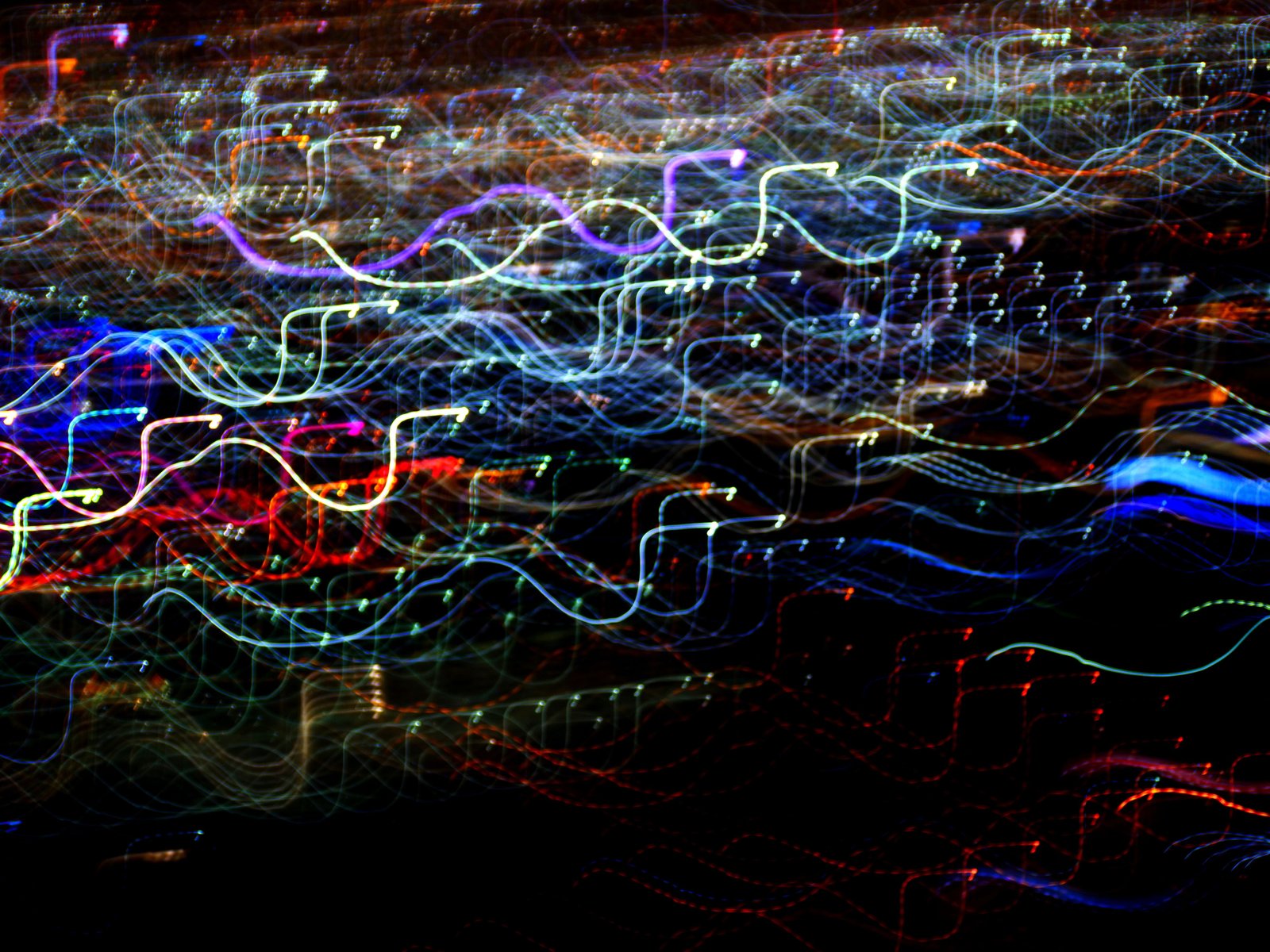 A dense tangle of overlapping colorful light trails against black, evoking excess signal and noise rather than clarity